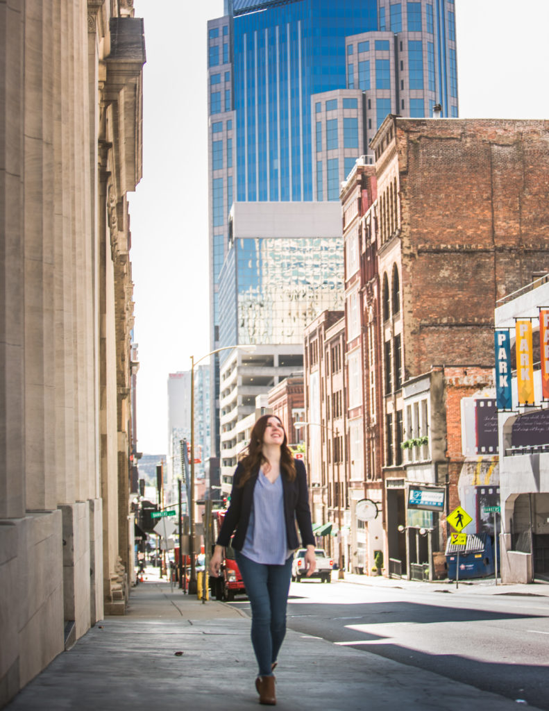A redheaded business woman named Anna-Vija walking down a street.