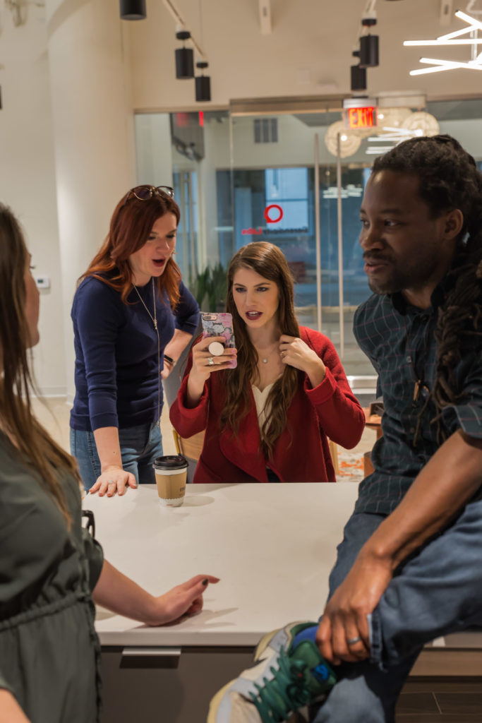 A diverse group of individuals sitting around a table, engaged in a meeting or discussion.